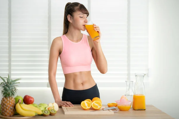 Menina asiática fazer um suco de laranja à mão em casa depois de terminado e — Fotografia de Stock