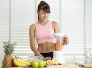 Asyalı kız meyve suyu yapmak için malzeme hazırla.