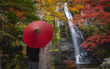 Japon çift için düğün öncesi fotoğraf ve kırmızı şemsiye.