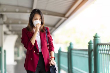 Asyalı kız tren istasyonunda Pm 2.5 ve Corona virüslerini veya covic 19 'u önlemek için koruyucu maske kullanıyor