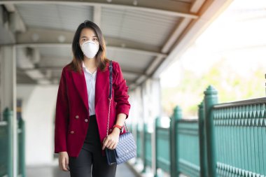 Asyalı kız tren istasyonunda Pm 2.5 ve Corona virüslerini veya covic 19 'u önlemek için koruyucu maske kullanıyor
