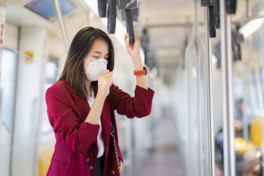 Asyalı kız tren istasyonunda Pm 2.5 ve Corona virüslerini veya covic 19 'u önlemek için koruyucu maske kullanıyor