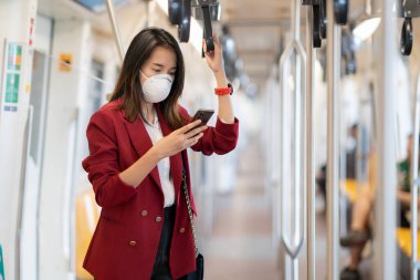 Asyalı kız tren istasyonunda Pm 2.5 ve Corona virüslerini veya covic 19 'u önlemek için koruyucu maske kullanıyor