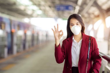 Asyalı kız tren istasyonunda Pm 2.5 ve Corona virüslerini veya covic 19 'u önlemek için koruyucu maske kullanıyor