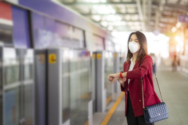 Asyalı kız tren istasyonunda Pm 2.5 ve Corona virüslerini veya covic 19 'u önlemek için koruyucu maske kullanıyor