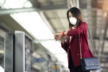 Asyalı kız tren istasyonunda Pm 2.5 ve Corona virüslerini veya covic 19 'u önlemek için koruyucu maske kullanıyor