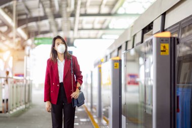 Asyalı kız tren istasyonunda Pm 2.5 ve Corona virüslerini veya covic 19 'u önlemek için koruyucu maske kullanıyor