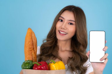 Marketten alışveriş çantası ve akıllı telefonla izole edilmiş Asyalı bir kız..