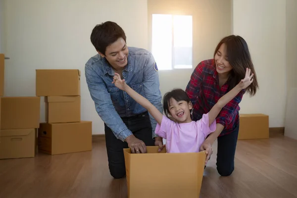 Happy asian family with cardboard boxes in new house at moving day.