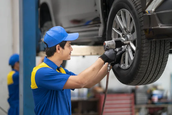 Mecánico Asiático Cambiando Rueda Coche Taller Reparación Automóviles Por Herramienta — Foto de Stock