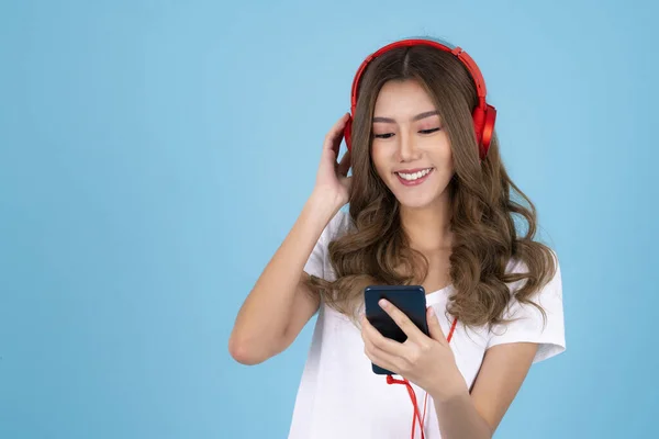 Kulaklıklı Asyalı Bir Kadın Mavi Izole Bir Arka Planda Müzik — Stok fotoğraf