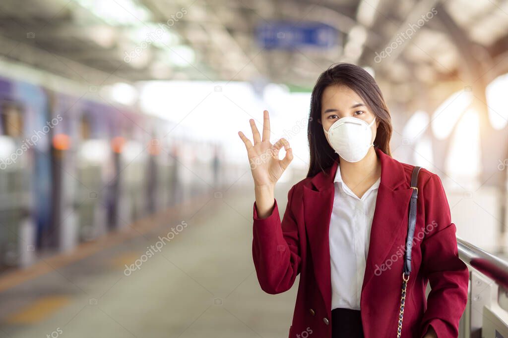 Asian girl use a protection mask for prevent PM 2.5 and corona viruus or covic 19 in train station
