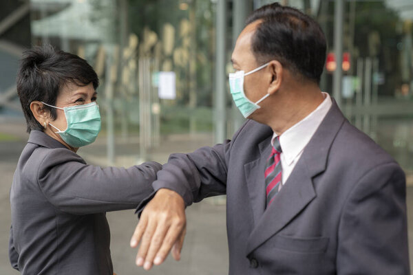 Old asian business people greeting togather by new methode with mask for prevent covid 19, this image can use for covid-19, corona virus and shakehands concept.