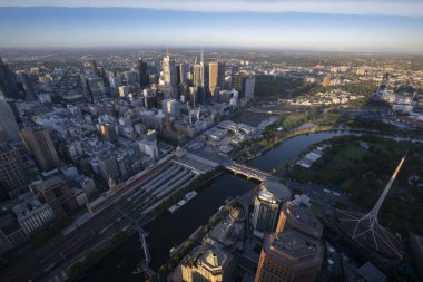 Melbourne şehir merkezindeki panorama yüksek bir noktadan. Avustralya. Şehir merkezindeki gökdelenlerin ve ufuktaki banliyölerin güzel manzarası. Gün batımı ve mavi bulutlar.