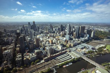 Melbourne şehir merkezindeki panorama yüksek bir noktadan. Avustralya. Şehir merkezindeki gökdelenlerin ve ufuktaki banliyölerin güzel manzarası. Gün batımı ve mavi bulutlar.