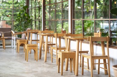 İçi boş ahşap masa ve kahve dükkanının ekoloji tasarımı duvarında yapay bitki süsü var. Yeşil ofis duvarında plastik bitkilerden sahte ağaç süslemesi var..