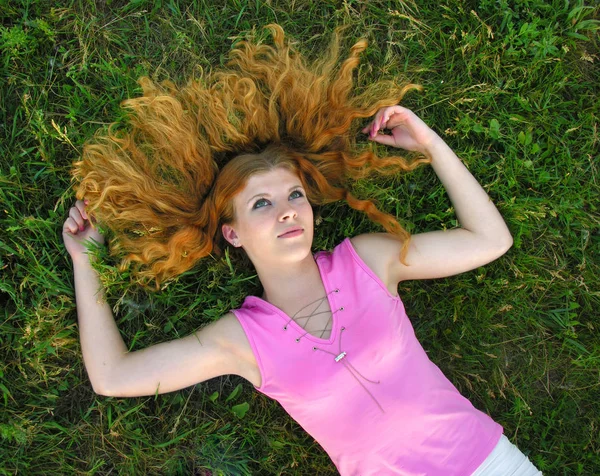 Giovane donna rossa sdraiata sull'erba — Foto Stock