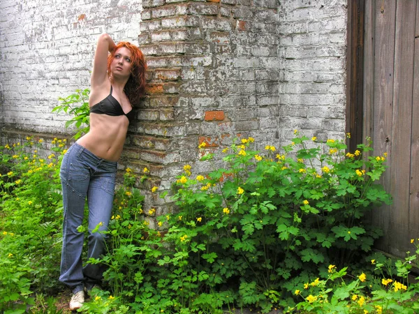 Young woman in black bra standing near old warehouse — Stock Photo, Image
