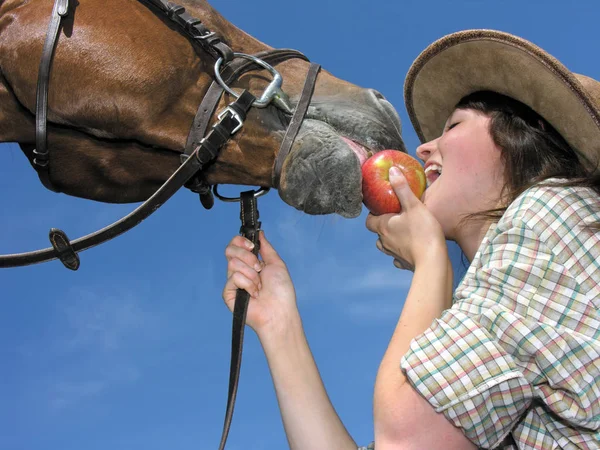 Joven vaquera y su amigo comiendo una manzana — Foto de Stock