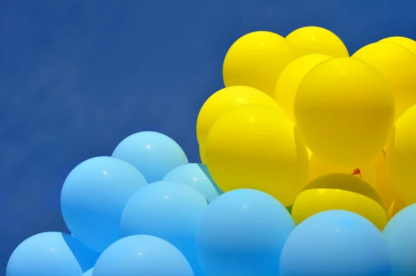 blue and yellow  balloons in the city festival on blue sky background