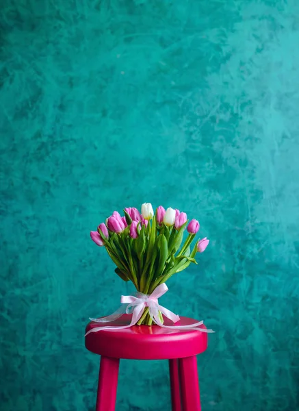 Bouquet of tulips on pink chair