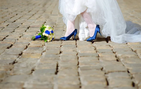 legs in blue high heel shoes at street near blue and white weddi