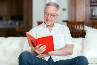 Kitap okuyan olgun bir adam.