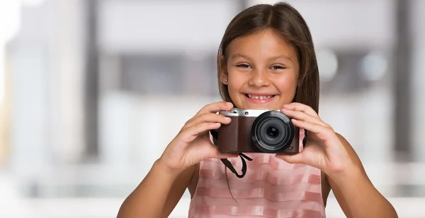 Petite fille tenant une caméra compacte — Photo
