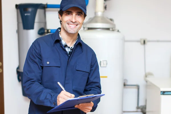 Technicus onderhoud van een warmwaterverwarmingstoestel — Stockfoto