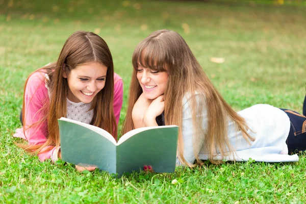 Mädchen lesen gemeinsam ein Notizbuch — Stockfoto