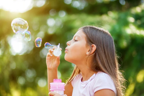 Дитина дме мильні бульбашки — стокове фото