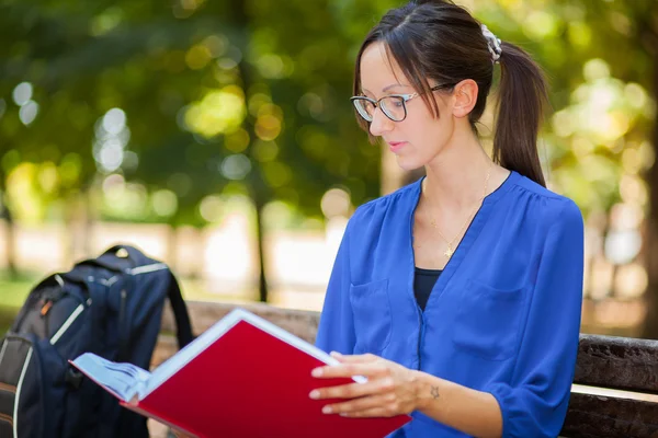 Kvinnlig student läsebok i parken — Stockfoto