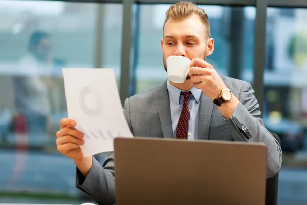 Affärsman läsa dokument och dricka kaffe — Stockfoto