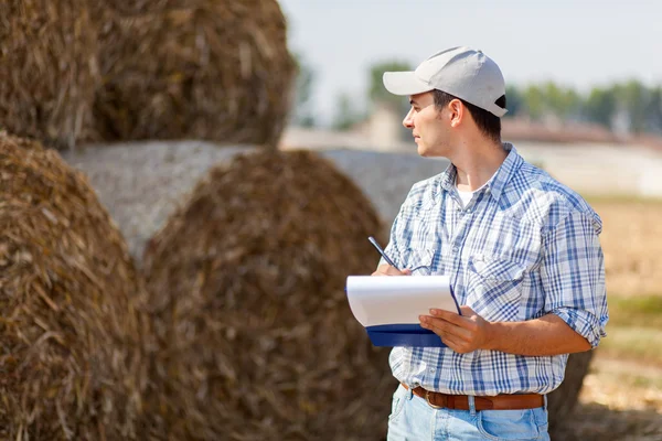 Farmer in a meadow holding folder — Stock Photo, Image