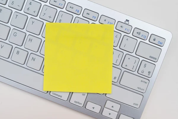 Желтый стикер на клавиатуре — стоковое фото