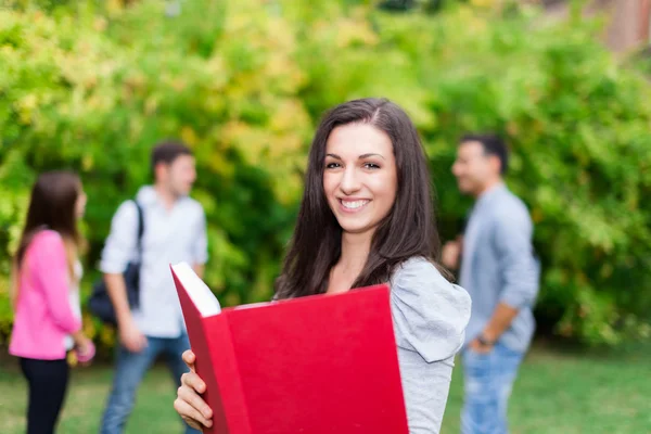 Kvinnlig student anläggning bok — Stockfoto