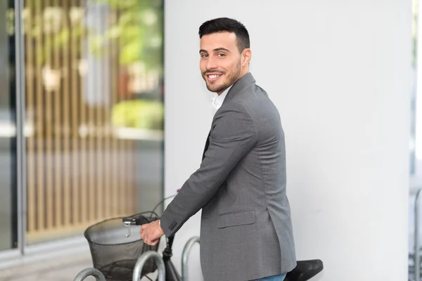 Uśmiechający się biznesmen parking jego rower — Zdjęcie stockowe