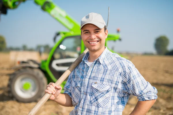 Granjero sonriente sosteniendo una horquilla — Foto de Stock