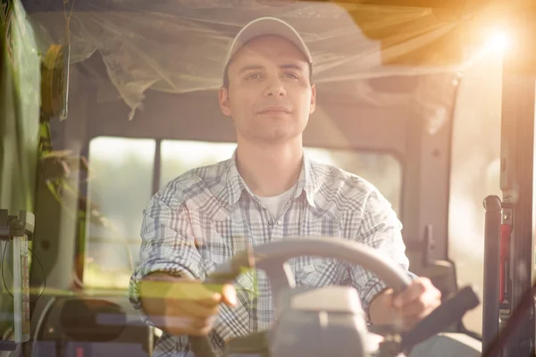 Boer een trekker rijden in veld — Stockfoto