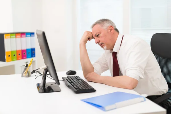 Stressad affärsman tittar på en dator — Stockfoto