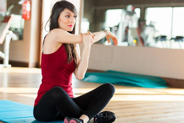 Mujer haciendo estiramiento en gimnasio —  Fotos de Stock