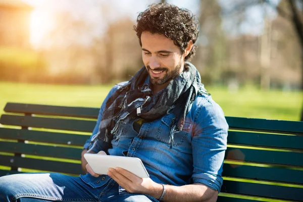 Man met zijn tablet in een park — Stockfoto