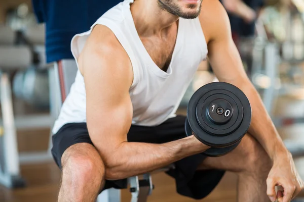 Bodybuilder using dumbbell to work out — Stock Photo, Image