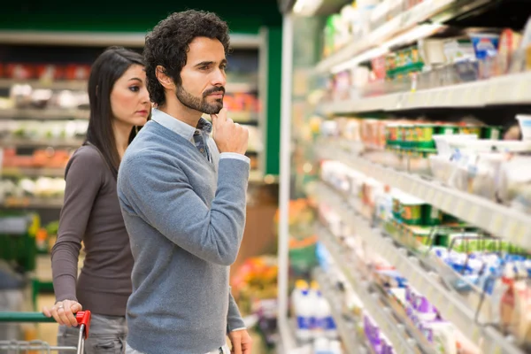 Couple choosing food in supermarket — Stock Photo, Image