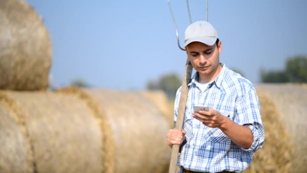 Farmář, pomocí jeho smarphone venkovní — Stock video