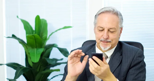 Zakenman te typen op zijn telefoon — Stockfoto