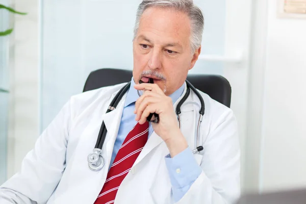 Senior doctor working in office — Stock Photo, Image