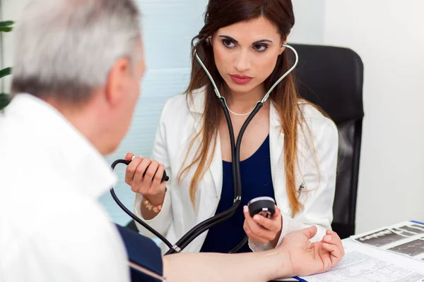 Médico usando estetoscopio y esfigmomanómetro — Foto de Stock