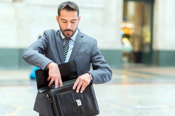 Uomo d'affari controllando la sua valigetta — Foto Stock