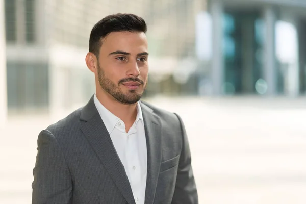 Hombre de negocios sonriente en el entorno empresarial — Foto de Stock